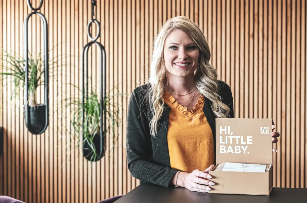 Frau in einem Raum, die ein Babypaket präsentiert