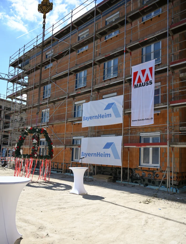 Richtfest Dinkelsbühl, Rohbau mit Gerüst im Hintergrund, Baubanner auf Fassade, Richtkrone auf der linken Seite