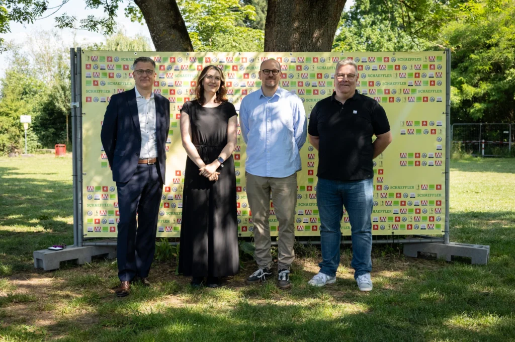 Gruppenfoto der Hauptsponsoren der Kulturinsel Wöhrmühle 2025, stehend vor einer bunten Sponsorenwand, lächeln in die Kamera