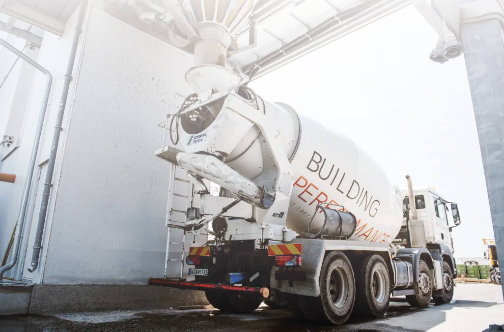 Fahrbarer Betonmischer wird im Betonmischwerk über den Trichter befüllt