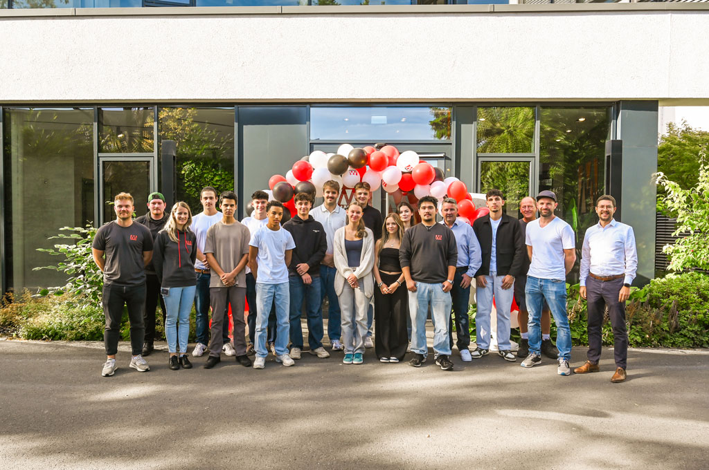 Gruppenbild Azubistart 2025, Ballons im Hintergrund, draußen
