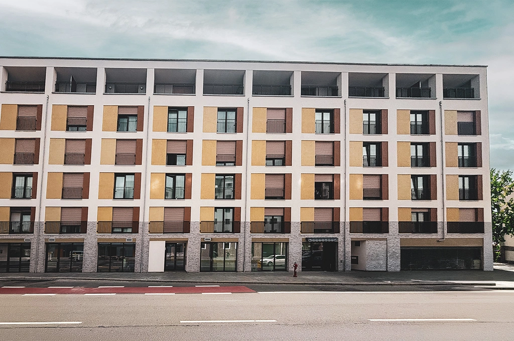 Fünfgeschossiges Bürogebäude mit gelb-weißer Fassade und großen Fenstern an einer breiten Straße.
